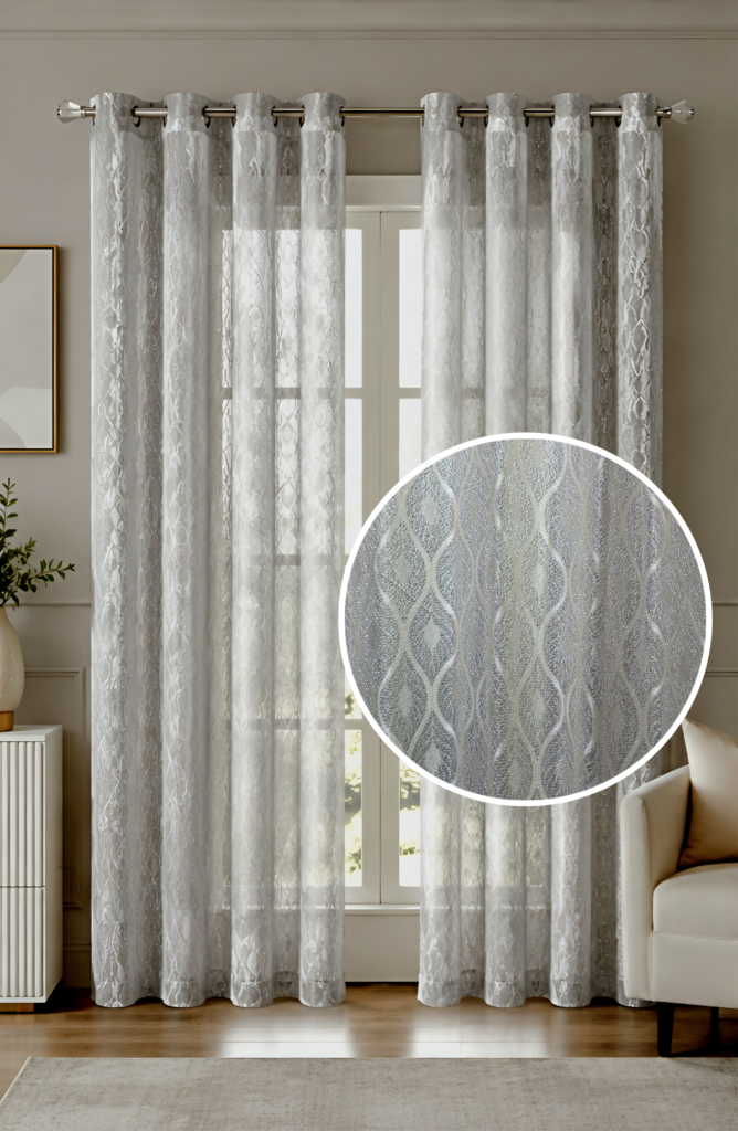 A beautifully lit window dressed with premium silver semi-sheer curtains featuring a shimmering metallic ogee wave pattern